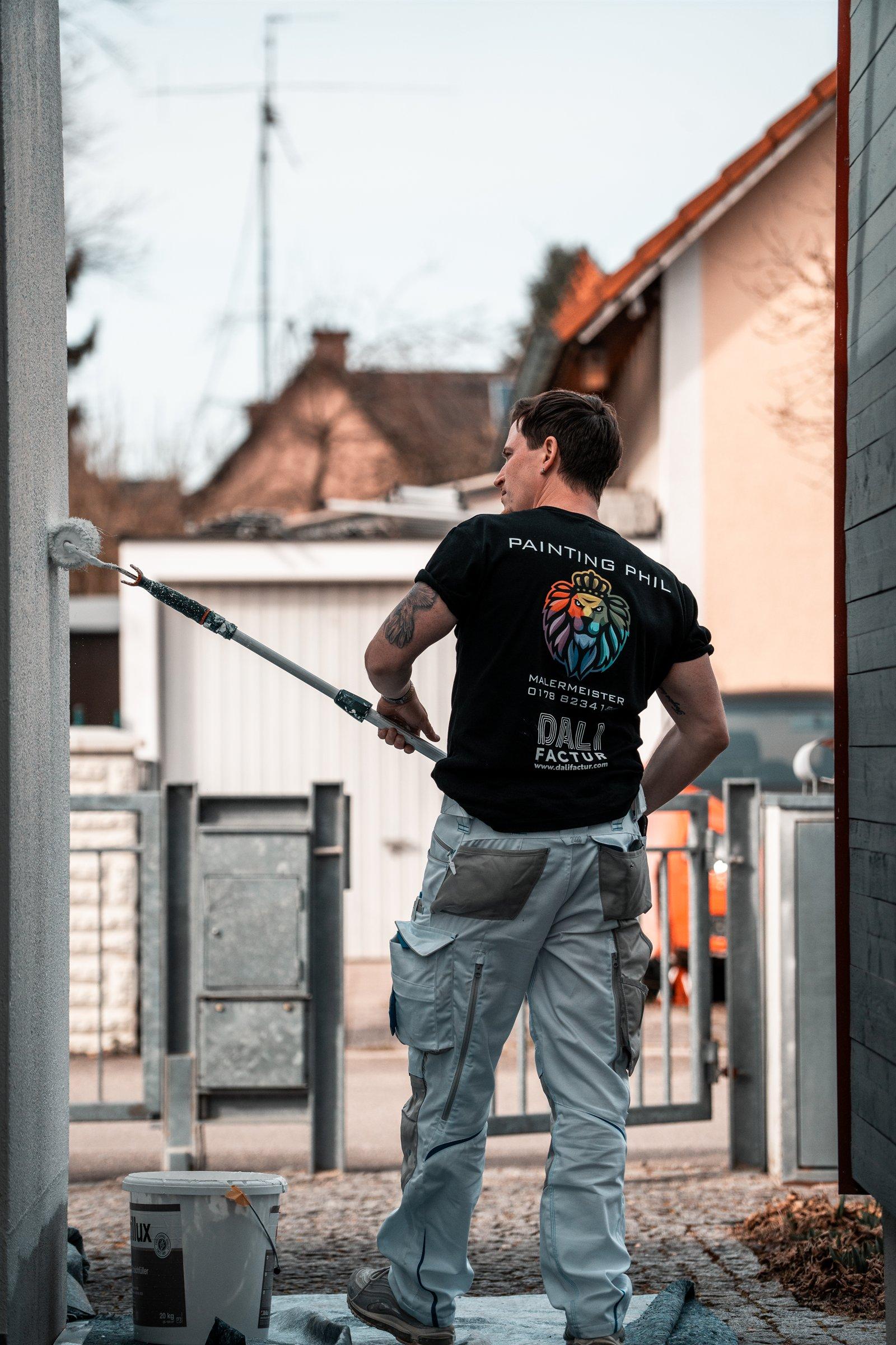 Phil Schlieckriede bei Malerarbeiten an einer Fassade in München